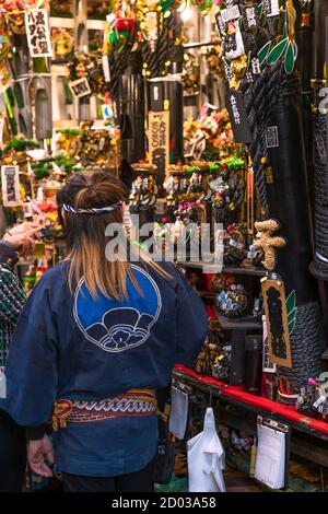 asakusa, japan - november 08 2019: Frau mit Chapatsu-Haaren auf der Tori-no-Ichi Fair in einem traditionellen japanischen Happi geradlinigen Mantel mit einer Kre Stockfoto