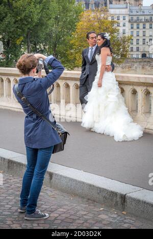 Brautpaar posiert für Fotos entlang Pont Marie, Paris, Frankreich Stockfoto