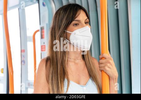 Frau Beifahrer trägt medizinische Hygiene schützen Maske. Steht in der U-Bahn-Zug Pendler in der Stadt. Hochwertige Fotos Stockfoto