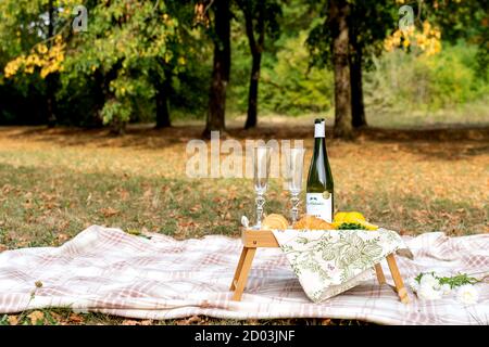 Holztablett mit Croissants und Wein auf einem Picknick. Stockfoto