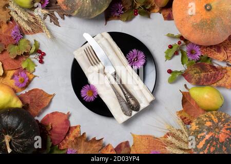 Herbsternte Rahmen mit Kürbissen, Birnen, Blätter, Blumen, Viburnum, Ähren von Weizen und schwarzen Teller in der Mitte. Blick von oben Stockfoto