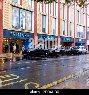 London, Großbritannien, Oktober 02 2020, Niederlassung des Einzelhandelsriesenprimark mit EINER Linie von Black Cab Taxis geparkt draußen Stockfoto