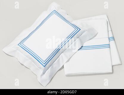 Weiß und blau Kissenbezug und Bettlaken auf weißem Hintergrund fotografiert. Stockfoto
