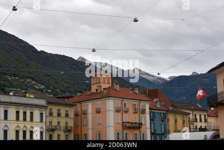 Piazza Grande mit Schweizer Nationalflagge, der Hauptplatz in Locarno, Kanton Tessin in der Schweiz, umgeben von Hügeln. Über dem Platz gibt es Lichter. Stockfoto