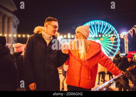 Gemeinsam Schlittschuhlaufen. Romantischer Winterurlaub in der Eisarena. Junges Paar Schlittschuhlaufen auf der Eisbahn. Das beste Weihnachten überhaupt. Winterspaß. Süßer Valentinstag Stockfoto