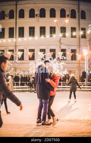 Gemeinsam Schlittschuhlaufen. Romantischer Winterurlaub in der Eisarena. Junges Paar Schlittschuhlaufen auf der Eisbahn. Das beste Weihnachten überhaupt. Winterspaß. Süßer Valentinstag Stockfoto