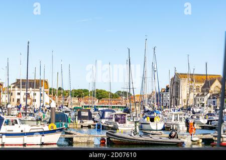 Weymouth, Großbritannien - 17. Juli 2020: Weymouth Marina mit vielen Booten angedockt und Einkaufszentrum im Hintergrund Stockfoto