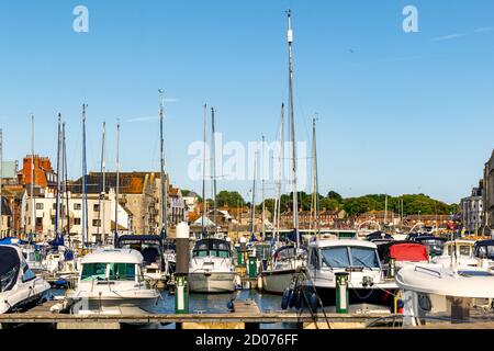 Weymouth, Großbritannien - 17. Juli 2020: Weymouth Marina mit vielen Booten angedockt und Einkaufszentrum im Hintergrund Stockfoto