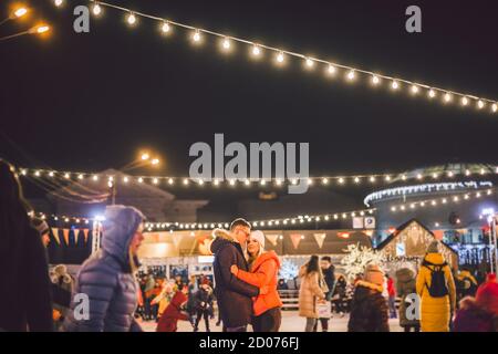 Gemeinsam Schlittschuhlaufen. Romantischer Winterurlaub in der Eisarena. Junges Paar Schlittschuhlaufen auf der Eisbahn. Das beste Weihnachten überhaupt. Winterspaß. Süßer Valentinstag Stockfoto