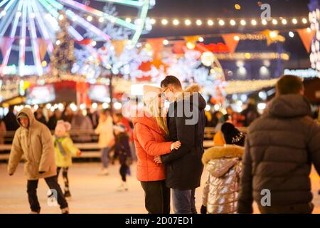 Ein junges kaukasisches Paar verbringt Neujahr und Weihnachten Urlaub in einer aktiven und sportlichen Art und Weise auf die Stadt Eisarena auf dem Platz in der Stadt Stockfoto