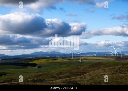 Ein Blick von der Spitze des Berges in der Nähe von Caersws Einige Windturbinen, die durch das Sonnenlicht im beleuchtet werden Entfernung Stockfoto