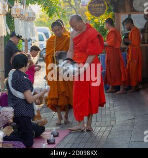 Lampeng, Tahiland - 2019-03-07-Linie der Mönche erhalten Geschenke von Nahrungsmitteln aus Anbeter entlang der Straße. Stockfoto