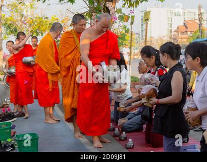 Lampeng, Tahiland - 2019-03-07-Linie der Mönche erhalten Geschenke von Nahrungsmitteln aus Anbeter entlang der Straße. Stockfoto