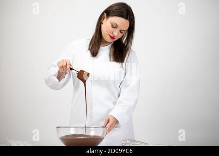 Attraktive Brünette Chocolatier macht luxuriöse handgemachte belgische Schokolade Stockfoto