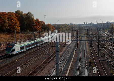 Helsinki, Uusimaa, Finnland 2020 2. Oktober 2020 Bahngleise und ein laufender Zug. Sonniger Herbsttag. Hochwertige Fotos Stockfoto