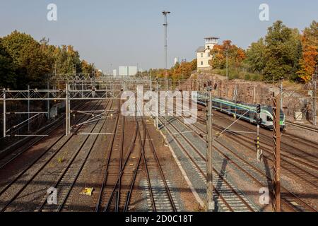 Helsinki, Uusimaa, Finnland 2020 2. Oktober 2020 Bahngleise und ein laufender Zug. Sonniger Herbsttag. Hochwertige Fotos Stockfoto