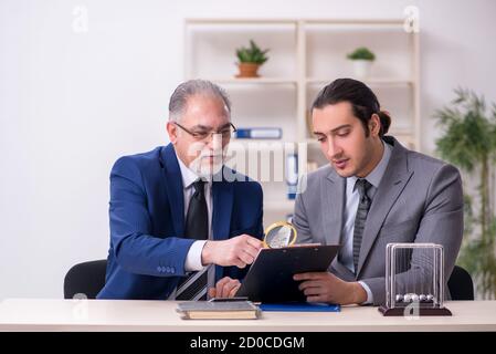 Zwei Geschäftsleute und Meditationskugeln auf dem Tisch Stockfoto