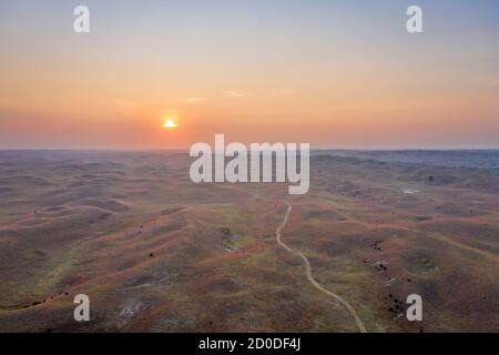 Verschwommener Sonnenaufgang über Nebraska Sandhills im Nebraska National Forest, Luftaufnahme der Herbstlandschaft, die von Waldbrandrauch aus Colorado und Wyoming betroffen ist Stockfoto