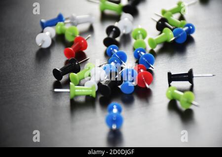 Bunte Punch Pins Zeichnung Pins auf schwarzem Hintergrund Stockfoto