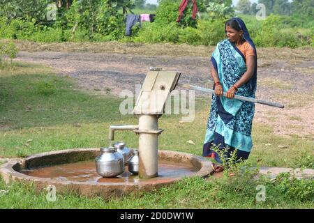 TIKAMGARH, MADHYA PRADESH, INDIEN - 14. SEPTEMBER 2020: Unbekannte Inderin, die Handpumpe für Trinkwasser verwendet. Stockfoto