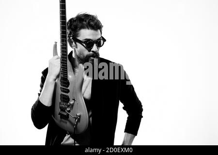 Ein Mann mit einer Gitarre Emotionen Musik Spiel Performance Leder Jacke Sonnenbrille Licht Hintergrund Stockfoto