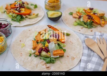 Offene vegane Tortilla Wraps mit Süßkartoffeln, Bohnen, Avocado und Kürbis Stockfoto