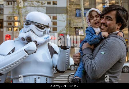 Teheran, Iran - 2019-04-03-Kind ist erschrocken, wenn ihm der Vater die Hand zu Star Wars Storm Trooper Zeichen an Street Fair. Stockfoto