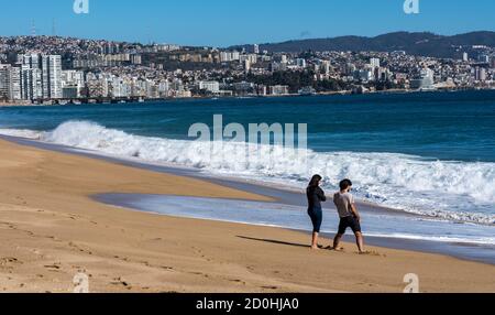 Valparaiso, Chile - 2019-07-30 - zwei Menschen am Strand entlang mit der Skyline im Hintergrund. Stockfoto
