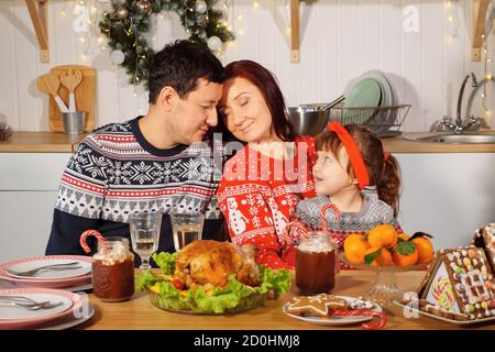 Glückliche Familie am Tisch am Silvesterabend. Stockfoto