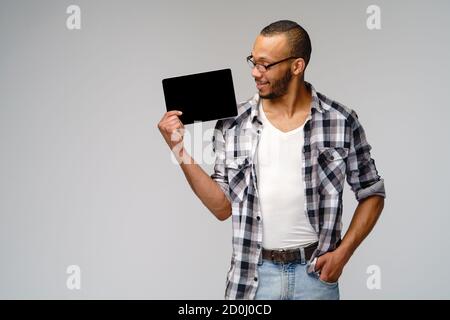 Porträt eines jungen afroamerikanischen Mannes mit grünem T-Shirt Halten des Tablet-pc-Pads Stockfoto