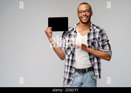 Porträt eines jungen afroamerikanischen Mannes mit grünem T-Shirt Halten des Tablet-pc-Pads Stockfoto