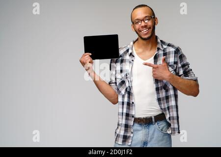 Porträt eines jungen afroamerikanischen Mannes mit grünem T-Shirt Halten des Tablet-pc-Pads Stockfoto