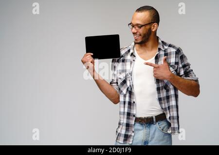 Porträt eines jungen afroamerikanischen Mannes mit grünem T-Shirt Halten des Tablet-pc-Pads Stockfoto