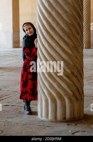 Shiraz, Iran - 2019-04-08 - Frau steht neben einer Kannelierten Säule von vakil Moschee. Stockfoto