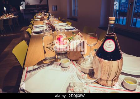 Panzano, Chianti, Italien - August 29 2020: Officina della Bistecca by Dario Cecchini Restaurant Interieur mit Tisch und Wein Stockfoto