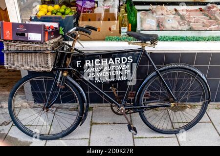 Ein traditionelles Metzgerfahrrad vor einem Metzgerladen, High Street, Lewes, East Sussex, Großbritannien. Stockfoto