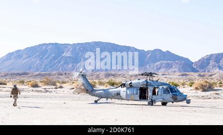 201001-N-PH222-1228 NAF El Centro, CA (Okt 01, 2020) Naval Aircrewman (Hubschrauber) 2. Klasse Silvio Huebner-Schurch, von Santa Barbara, Kalifornien, links, Spaziergänge zu einem MH-60S Knighthawk Hubschrauber zugeordnet zu den "Black Knights" von Hubschrauber Sea Combat Squadron (HSC) 4, während einer Übung in Naval Air Facility El Centro, Calif. HSC 4 bietet vertikale Aufzugssuche und -Rettung, Logistik, Anti-Oberflächen-Kriegsführung, spezielle Operationen Streitkräfte Unterstützung und Kampfsuchungs- und Rettungsfähigkeiten. (USA Navy Foto von Mass Communication Specialist 2nd Class Ryan M. Breeden) Stockfoto