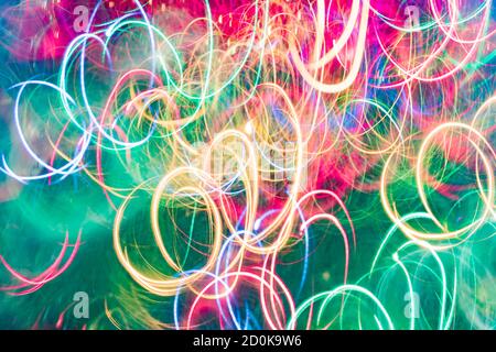 Multicolor neon grün und rosa Lichter Trails Hintergrund. Bokeh-Streulicht. Festlicher Hintergrund Stockfoto