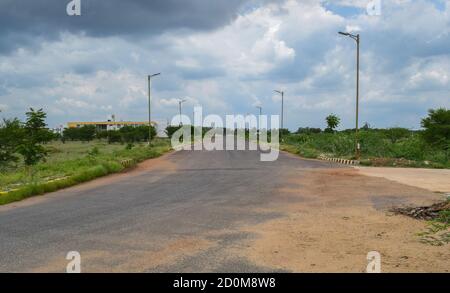 Menschenleere breite Straße mit schönem Himmel und Straßenlaterne ausgerichtet Perspektive, symmetrisch. Leer wegen COVID-19 Pandemie Lockdown Stockfoto