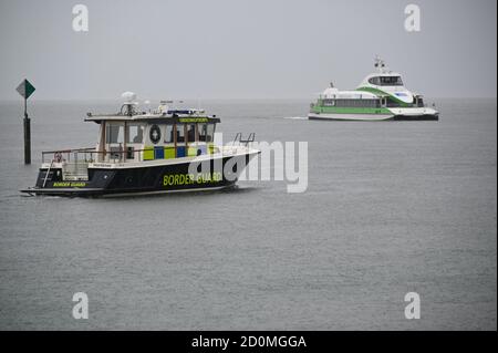 Konstanz, Deutschland. Oktober 2020. Ein Einsatzboot (l) des Schweizer Grenzschutzkorps (GWK) segelt auf dem Bodensee nahe der Bodenseeseite. Die Menschenkette soll durch Deutschland, Österreich, Liechtenstein und die Schweiz gehen. Quelle: Felix Kästle/dpa/Alamy Live News Stockfoto