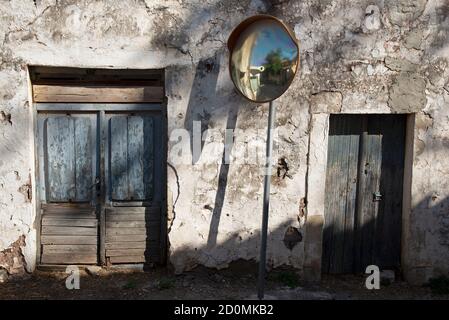 Verwitterte Türen, die zu einem Gebäude gehören, das vor vielen Jahren als Lebensmittelgeschäft genutzt wurde, in einem Dorf in der Region Psiloritis, Kreta, Griechenland. Stockfoto