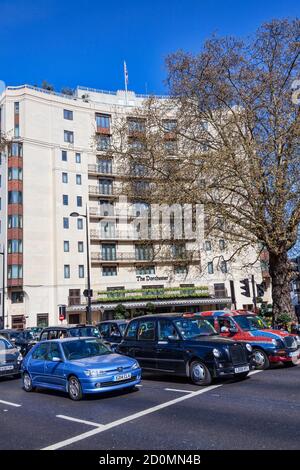 London, UK, April 1, 2012 : The Dorchester Hotel Business on Park Lane Mayfair Hyde Park with parking for a black Taxi cab which is a popular travel d Stockfoto