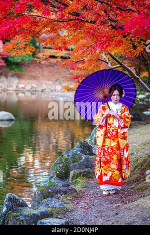 Eine schöne junge japanische Mädchen in einem bunten Kimono im Nara Park gekleidet. Stockfoto