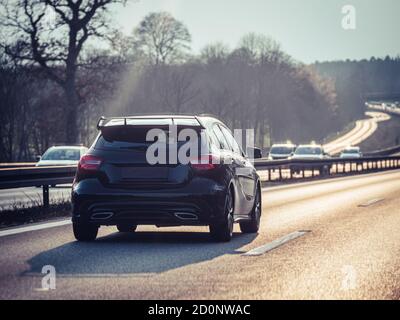 Schwarzsportwagen auf der deutschen Autobahn, selektiver Fokus verschwommen Hintergrund Stockfoto