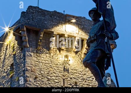 Enego: Das Denkmal für die Gefallenen des Großen Krieges und der mittelalterliche Turm, der von den Scaligeri gebaut wurde. Hochebene von Asiago, Provinz Vicenza, Venetien, Italien. Stockfoto