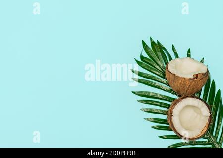 Hälften von frischer roher Kokosnuss auf blauem Hintergrund. Stockfoto
