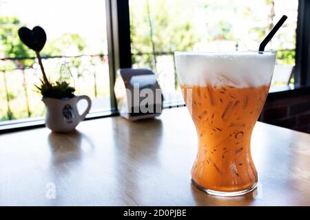 Eismilchtee in großem Glas im Café-Restaurant in Nonthaburi, Thailand Stockfoto