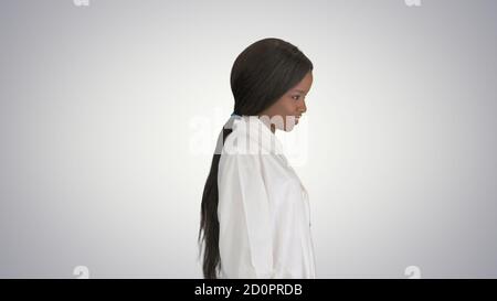Hübsche afroamerikanische Ärztin posiert auf gradient backgro Stockfoto