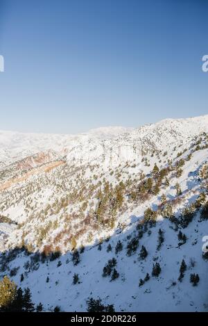 Das majestätische Tien Shan Gebirge im Winter in Usbekistan. Wunderbare Winterlandschaft. Atemberaubende Hochland an einem sonnigen Tag. Herrliche Aussicht auf schneebedeckte m Stockfoto