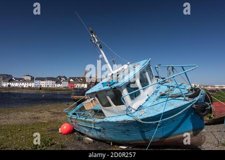 Alte bunte blaue Fischerboot und Häuser in der Ferne Der Claddagh Gegend von Galway Stadt.Irland Stockfoto